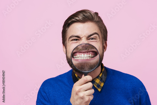 Bilde på lerret Man holding magnifying glass against open mouth
