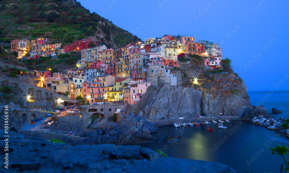 Manarola, Liguria, Italy. Beautiful wonderful village as you can see it from the mountain above. Quiet sky and peaceful sea, during sunset background.