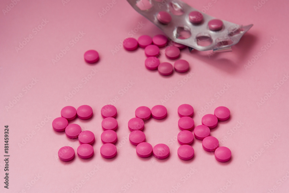 Pink pills on a pink background. The word 