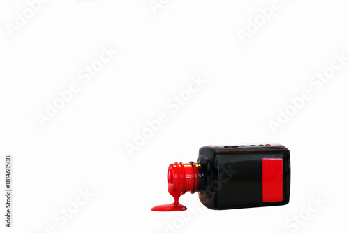 Red nail polish bottle with isolated on white. Nail polish pouring from bottle