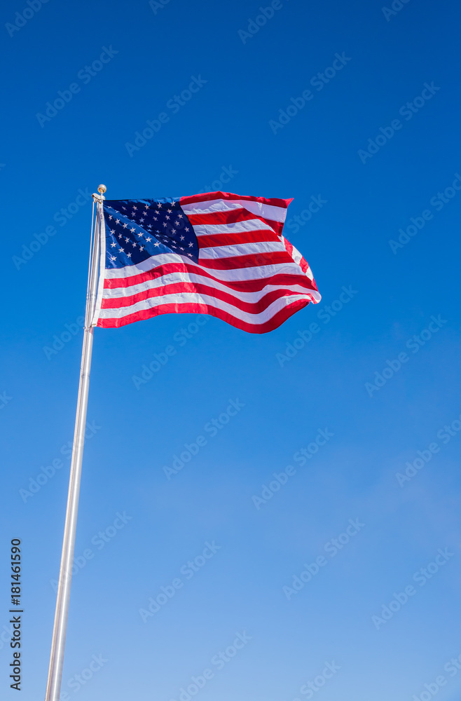 USA American Flag waving with clear blue sky background in Veritcal view