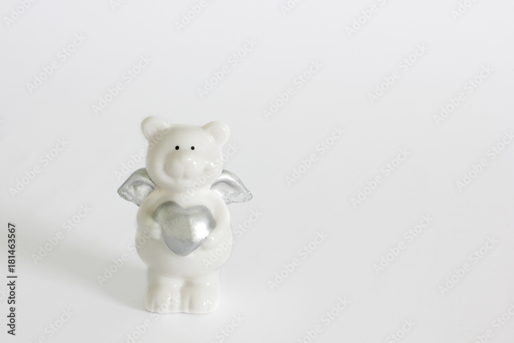 porcelain teddy bear with a heart on a white background. love porcelain teddy bear with a heart on a white background. love