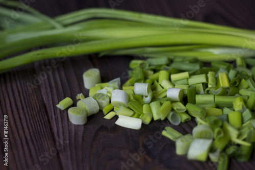 chopped onions and green onions on a wooden table