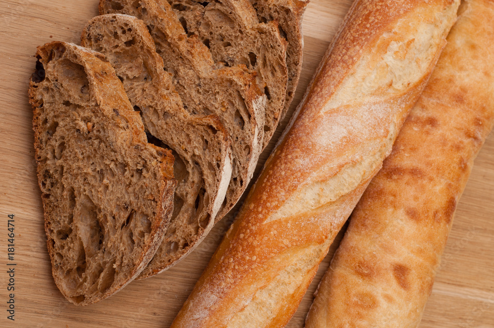 sliced French black bread and two baguettes