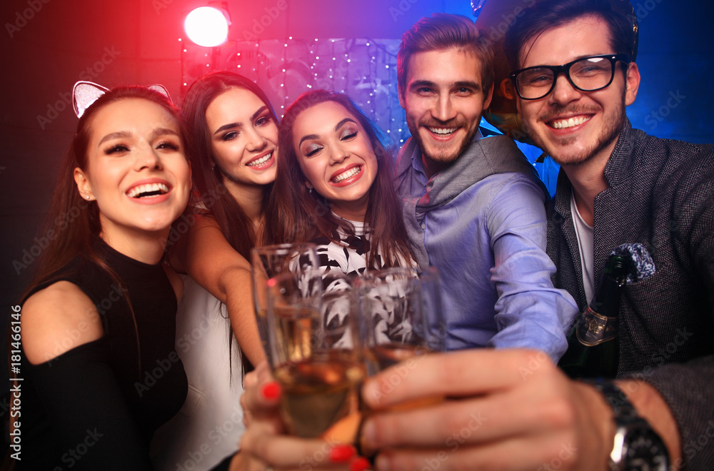 Enjoying amazing party. Group of beautiful young people dancing with champagne flutes and looking happy. Enjoying amazing party. Group of beautiful young people dancing with champagne flutes and looking happy.