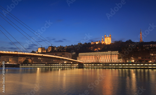 Panorama of footbridge ’Passerelle Palais du Justice’ over the Saone river in Lyon, France, during twilight.