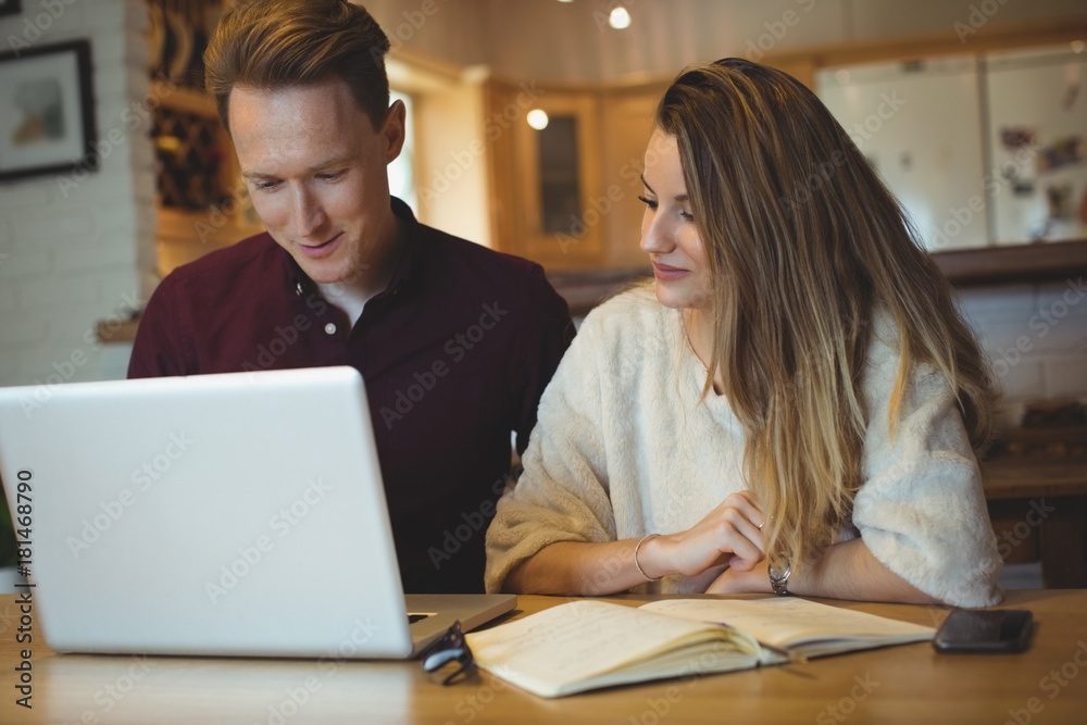 Couple using laptop on table Couple using laptop on table