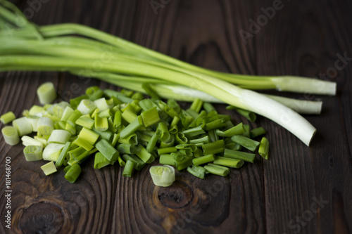 chopped onions and green onions on a wooden table