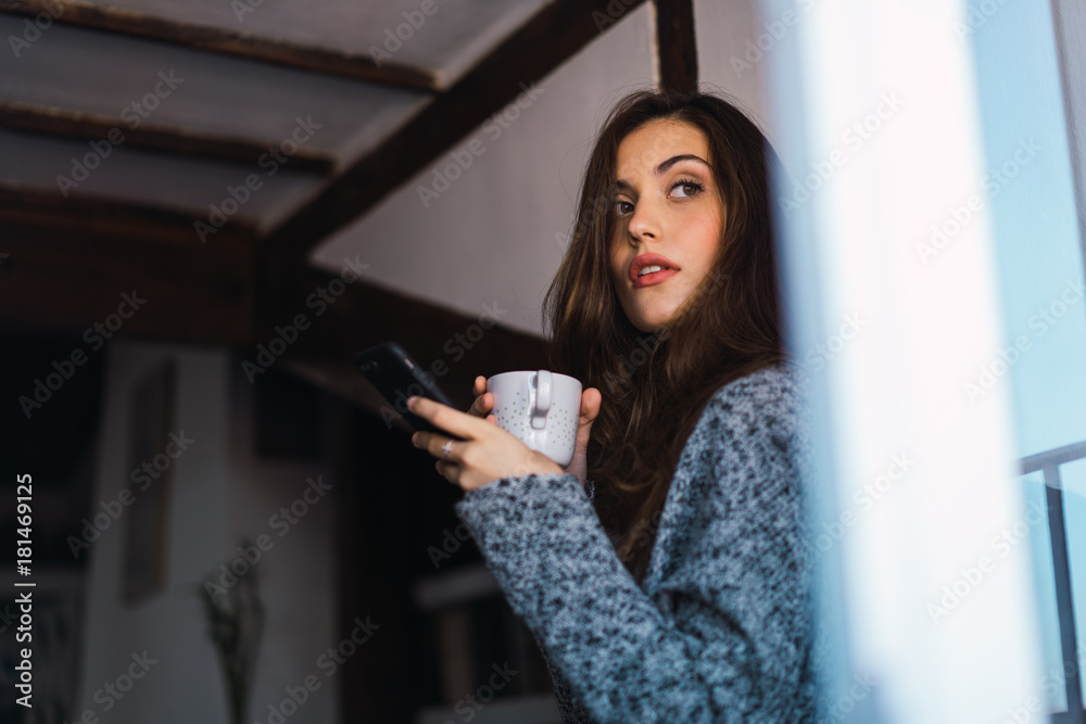 Beautiful model with cup of coffee and smartphone Beautiful model with cup of coffee and smartphone