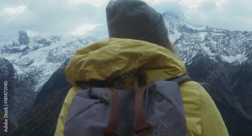 CRANE SHOT Beautiful Caucasian female hipster hiking in French Alps, enjoying the view of Mont Blanc massif. 4K UHD RAW 60 FPS SLO MO