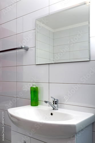 Fragment of the bathroom with a washbasin and a mirror