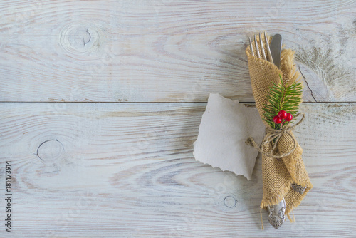 vintage cutlery in burlap napkin on rustic backgorund wiht copy space photo