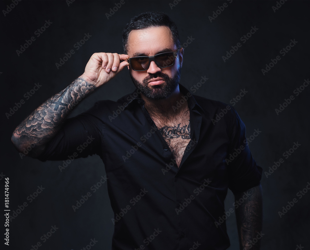 Fototapeta premium A man with tattoos on arms and neck.