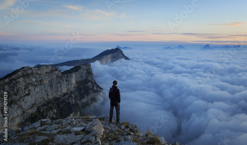 Man looking over a sea of clouds in the mountains. Vercors, France. photo