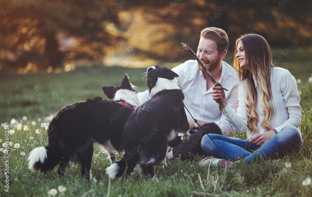 Romantic couple in love walking dogs in nature and smiling Romantic couple in love walking dogs in nature and smiling