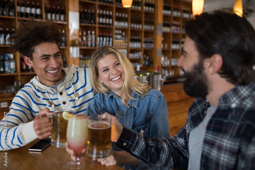 Friends toasting glass of drinks in bar