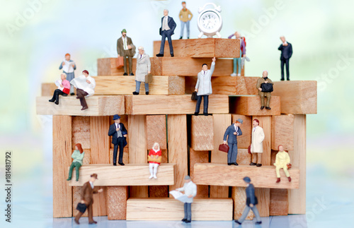 Miniature business people sitting on wood block , recruitment finding employee and business concept. photo