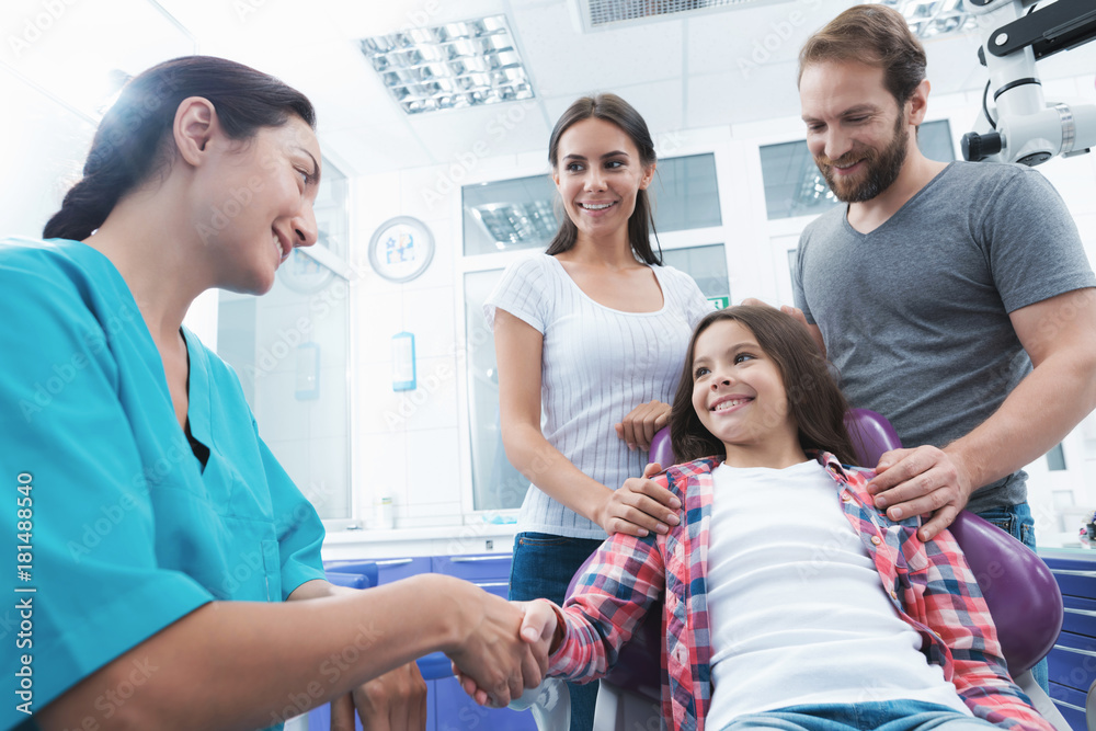 The woman's doctor has finished treating the girl. Next to the girl, her parents. The woman's doctor has finished treating the girl. Next to the girl, her parents.