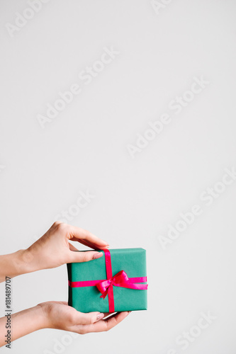 presenting an elegant gift on dark background. closed gift box wrapped of ribbon and a bow. pleasant surprise for birthday, new year, christmas, valentines day and other holidays.