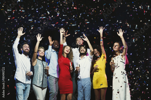 Happy young friends celebrating christmas at night club