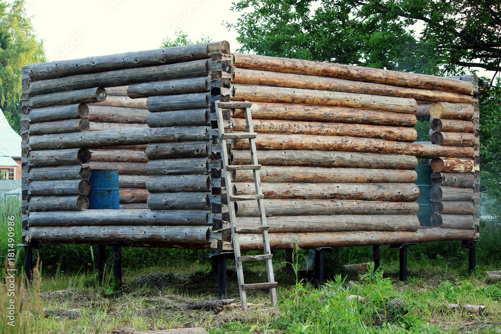 Assembling a wooden frame and building a house. Russia. Texture of old wooden logs and holes for the future door and windows. Assembling a wooden frame and building a house. Russia. Texture of old wooden logs and holes for the future door and windows.