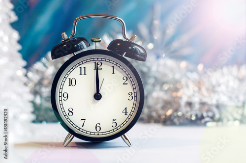 New Year alarm clock on a silver and blue background. New Year and Christmas decoration. Midnight.