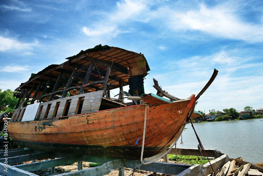 An abandoned wooden boat beside the river
