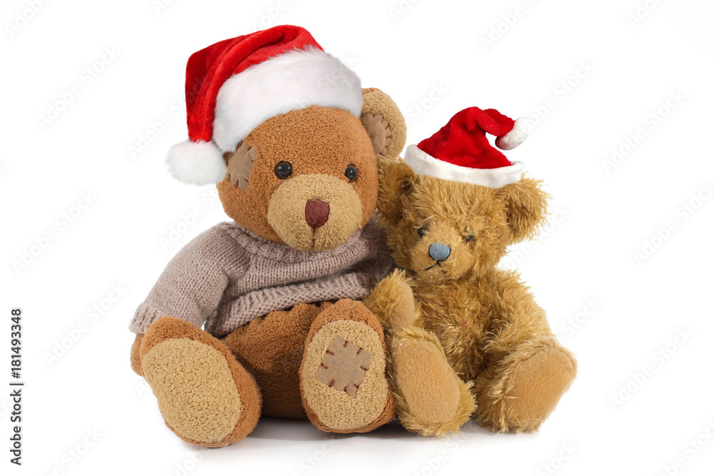 Two, sitting, cuddly stuffed teddy bears in a Santa Claus hat Two, sitting, cuddly stuffed teddy bears in a Santa Claus hat