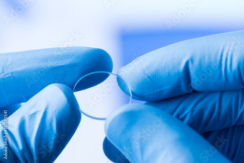 Scientist hold in hands small round piece of transparent glass, new type of glass or plastic with new properties research concept