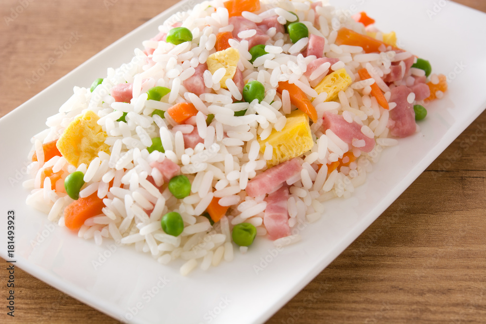 Chinese fried rice with vegetables and omelette on wooden table. Chinese fried rice with vegetables and omelette on wooden table.