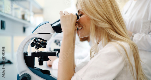 Young scientist looking through microscope in laboratory