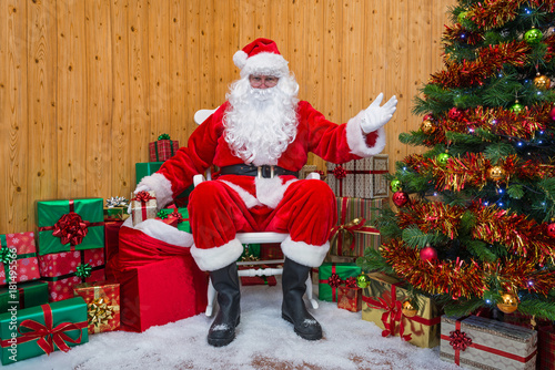 Santa Claus in a grotto handing out presents. photo