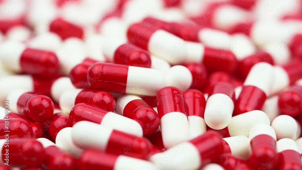 Red and white antibiotics capsule pills slide and moving from left to right. Drug resistance concept. Antibiotics drug use with reasonable. Global healthcare. Pharmaceutical industry. Red and white antibiotics capsule pills slide and moving from left to right. Drug resistance concept. Antibiotics drug use with reasonable. Global healthcare. Pharmaceutical industry.