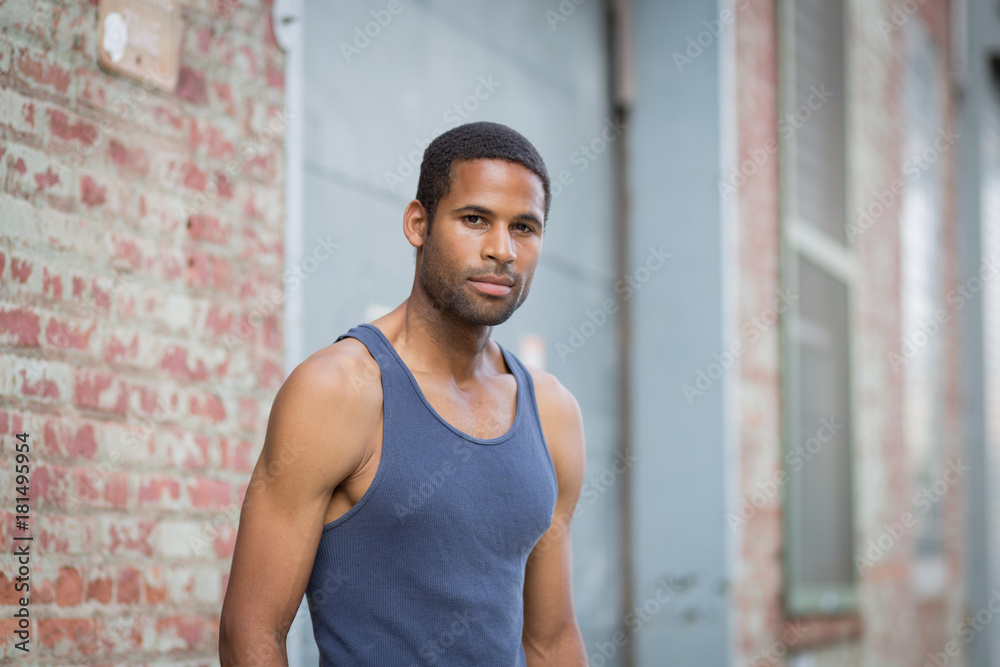 Young handsome African American man in tank top in the rough neighborhood Young handsome African American man in tank top in the rough neighborhood