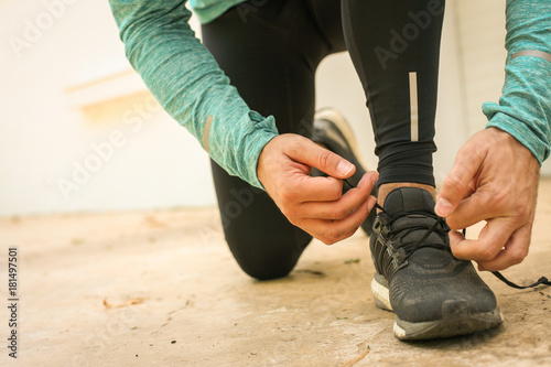 Man tying shoes before running.