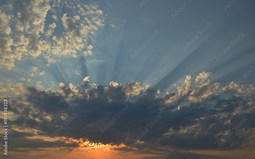 Sunrise with sun behind clouds with a blue sky in background