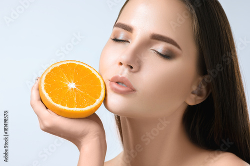 Beautiful woman's face with juicy orange