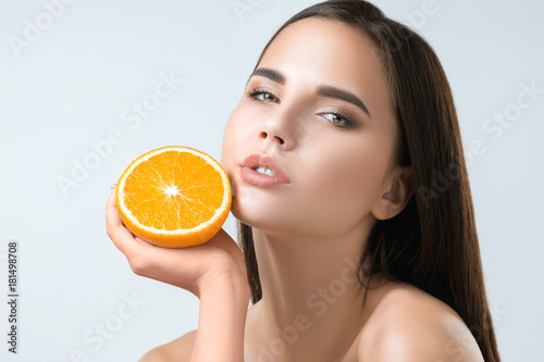 Beautiful woman's face with juicy orange