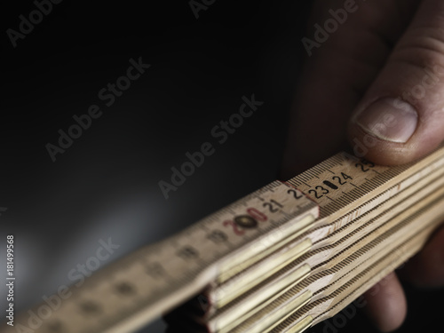 Close up wooden folding ruler with a hand