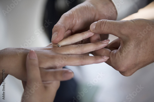 Man placing wedding ring on brides finger