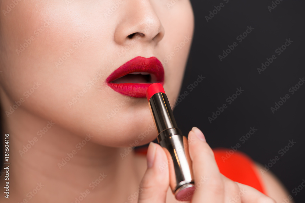 Professional Make-up. Attractive asian model applying red lipstick.