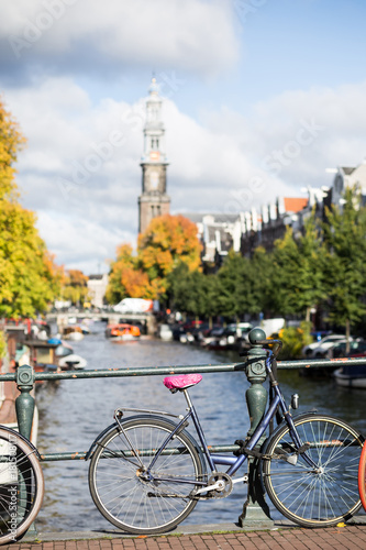 Amsterdam Holland Netherlands houses, blooming flowers, and bicycles near famous UNESCO world heritage canals Singel with typical dutch houseboats
