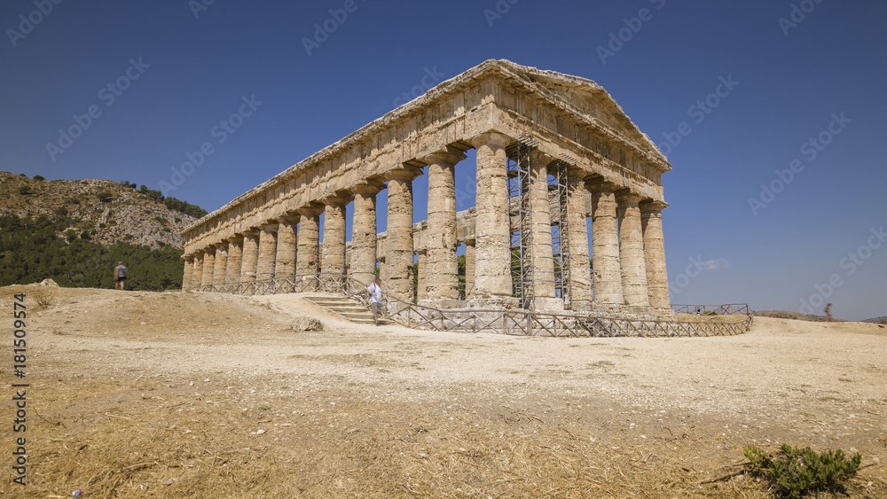 Some tourists visiting ancient Greek temple at Segesta in Sicily, Italy.