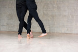 Dance partners training modern dance. Young couple of dancers performing element of contemporary dance, cropped image.