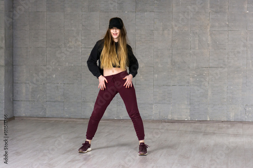 Casual girl dancer posing on grey background. Young caucasian modern style girl dancing contemporary dance in studio. School of modern dance.