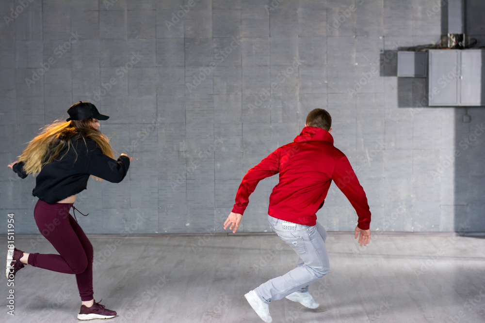 Young man and woman dancing modern dance. Couple of young man and woman dancing hip-hop dance at studio.