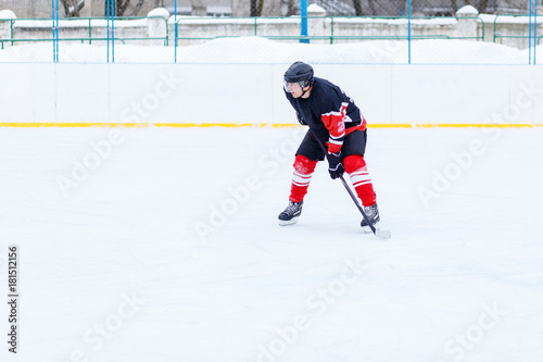 Ice hockey skater with stick on rink. Image with copy space