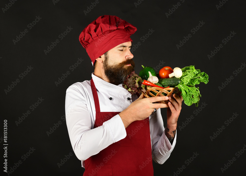 Chef holds lettuce, tomato, pepper and mushrooms.