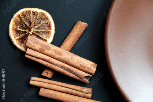 Dry slices of citrus on the background of black slate, cinnamon and anise photo