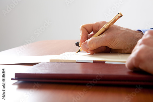 Closeup of a man writing documents